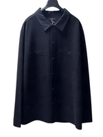 COS black long-sleeve cotton button-down shirt with two chest pockets, displayed on a hanger.