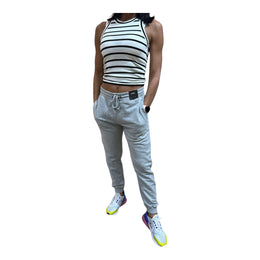 A woman wearing a grey sleeveless top and matching joggers with an elastic waistband, standing against a white background.