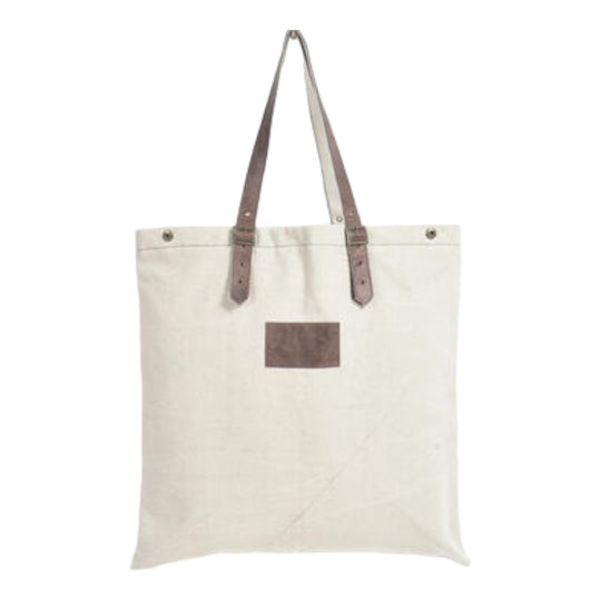 An off-white canvas tote bag with brown leather straps and hand stitching details.