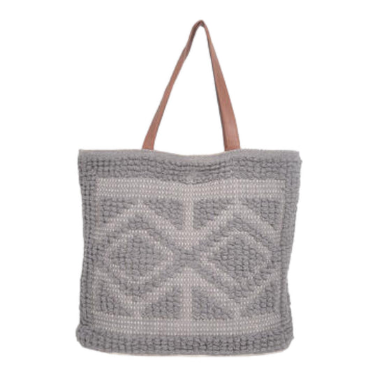 A gray tufted cotton tote bag with a geometric pattern, featuring leather straps and a magnetic clasp.