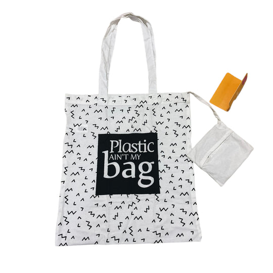A white cotton tote bag with black text and pattern, accompanied by a foldable pocket and a brand tag.