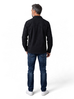 Back view of a man wearing a black COS long-sleeve cotton button-down shirt with a structured collar.