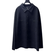COS black long-sleeve cotton button-down shirt with two chest pockets, displayed on a hanger.