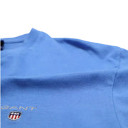 Close-up of GANT blue V-neck T-Shirt fabric texture and embroidered shield logo