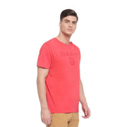 Angled front view of model wearing pink GANT logo shield T-shirt with short sleeves