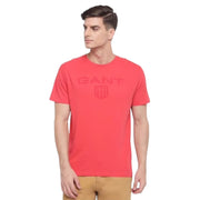 Model wearing GANT pink T-shirt with large shield logo printed on chest