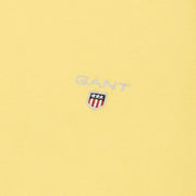 Close-up of Gant yellow T-Shirt logo – embroidered text and crest on chest