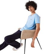 Front seated view of Lacoste light blue V-neck T-Shirt on male model lounging in chair