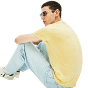 Back view of man sitting showing Lacoste yellow V-neck T-shirt