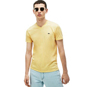 Front view of man wearing Lacoste yellow V-neck T-shirt with crocodile logo and light blue jeans