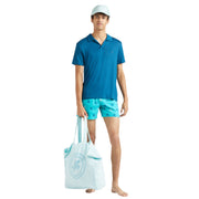 Full look of Vilebrequin blue polo shirt styled with beachwear, including tote bag and cap